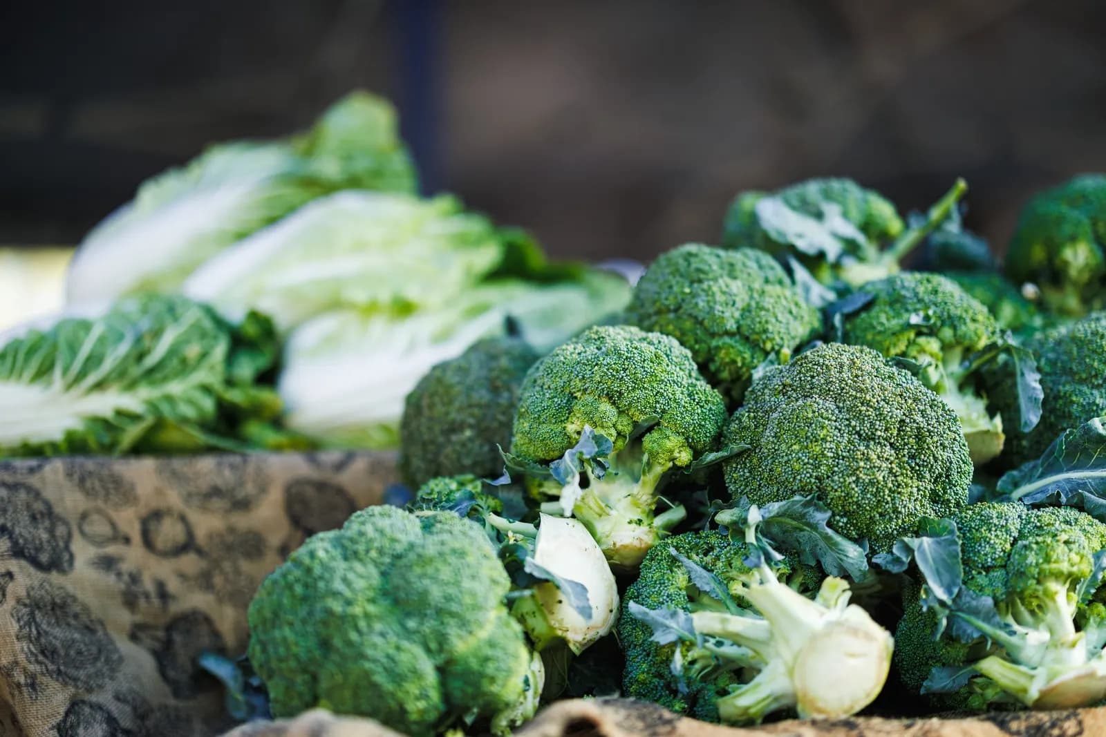 Broccoli and cabbages piled on a produce stall
