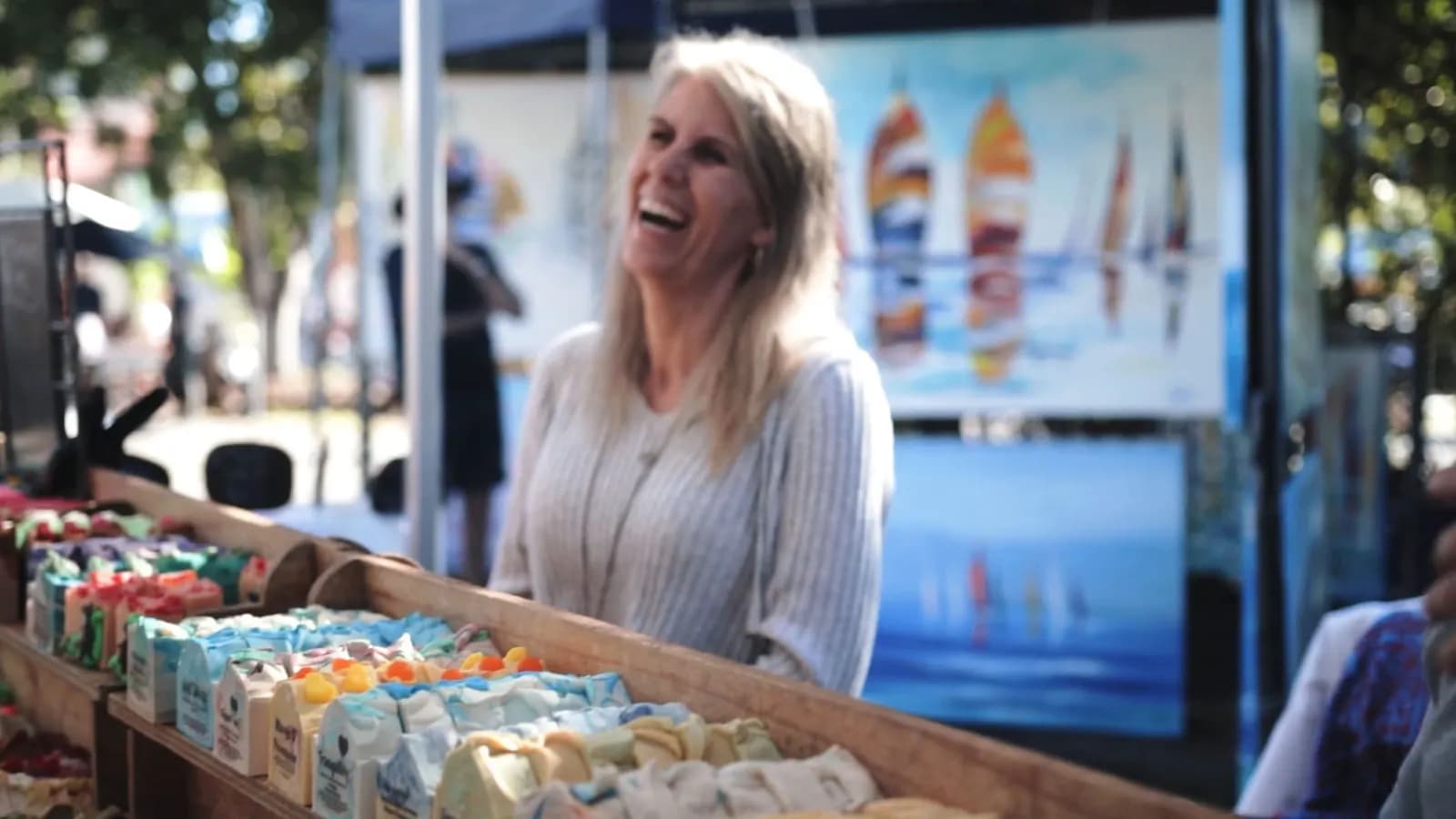 A stallholder behind a table of handmade soaps at Eumundi Markets