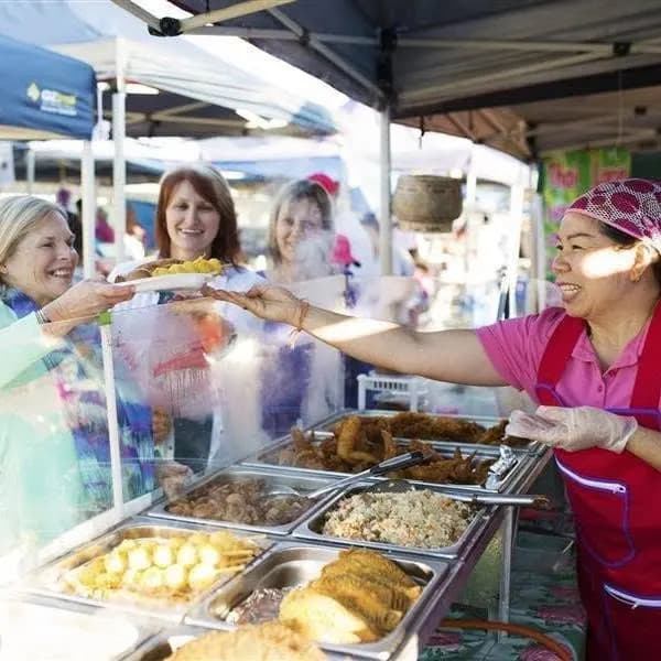 A stallholder serving hot food at Global Food Markets in Woodridge