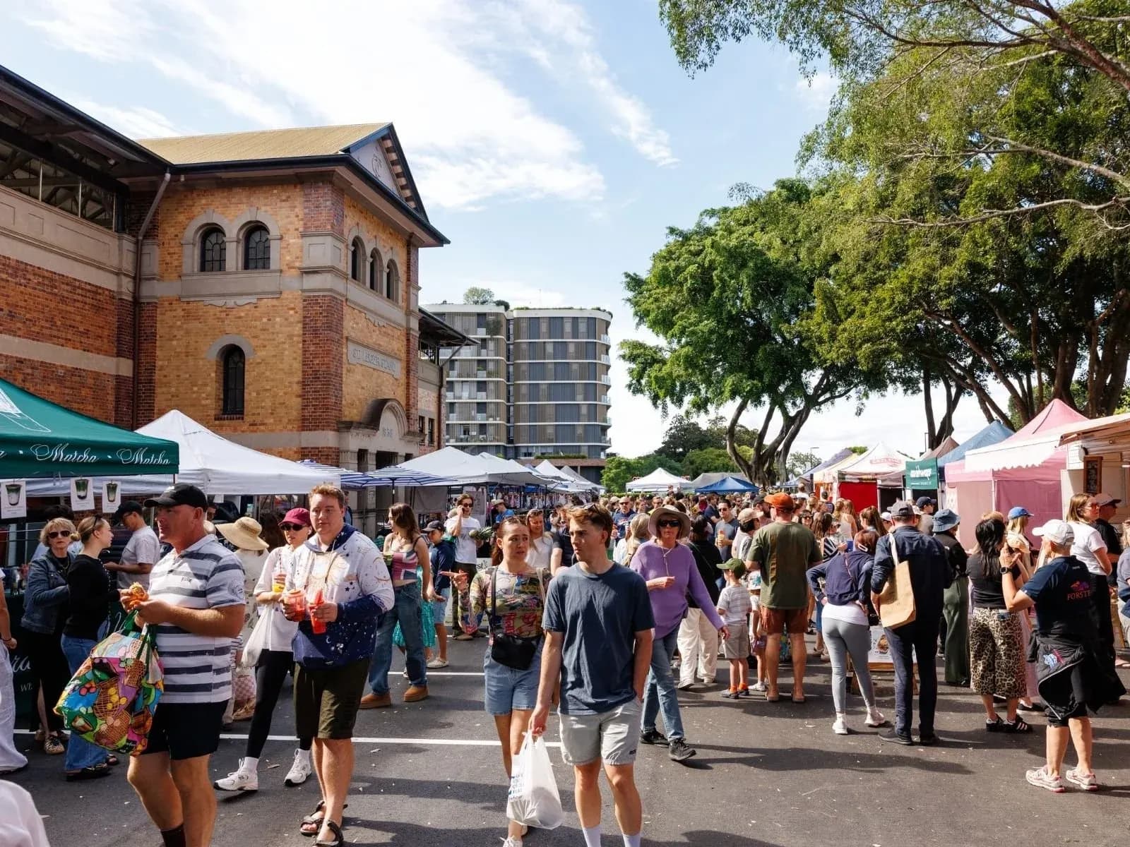 Crowds among the stalls beside the Brisbane Powerhouse at Jan Powers Farmers Markets