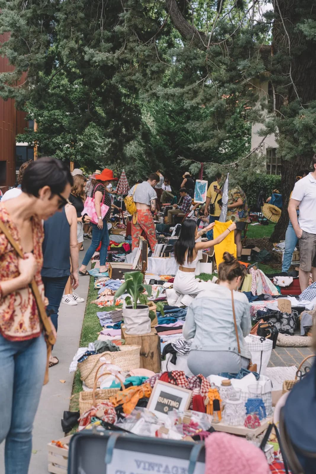 Shoppers browsing suitcases laid out on the ground at Suitcase Rummage in Brisbane