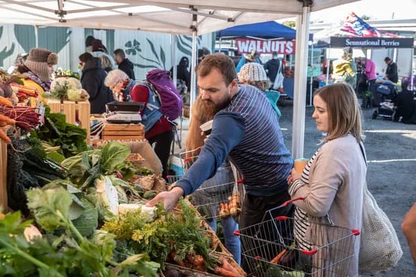 Shoppers choosing vegetables at Alphington Farmers Market