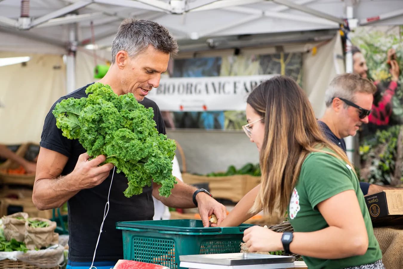 Stallholder handing over kale at an organic produce stall