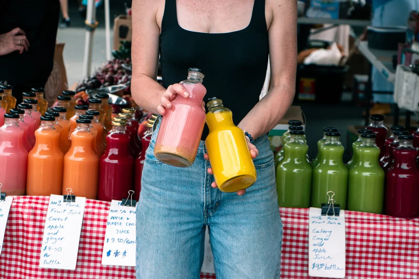 Stallholder holding bottles of juice at the Kawana Farmers Market